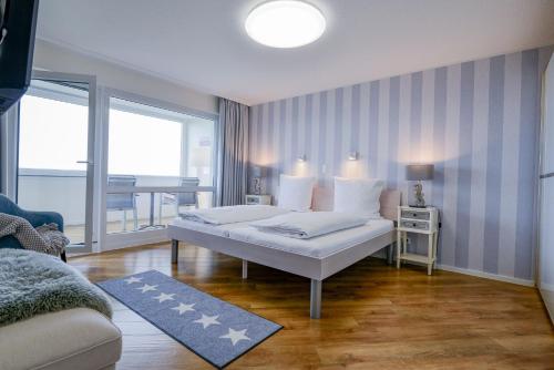 a bedroom with a bed and a living room at Am Sahlenburger Strand AS23 in Cuxhaven