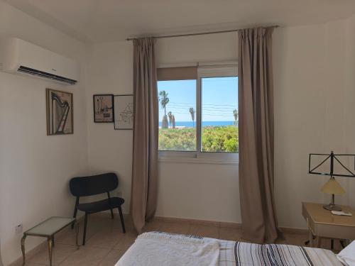 a bedroom with a window with a view of the ocean at Villa Arfa in Peyia