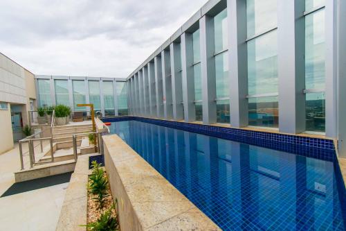 a swimming pool on the side of a building at Vision Hotel em Brasília 59854 in Brasília