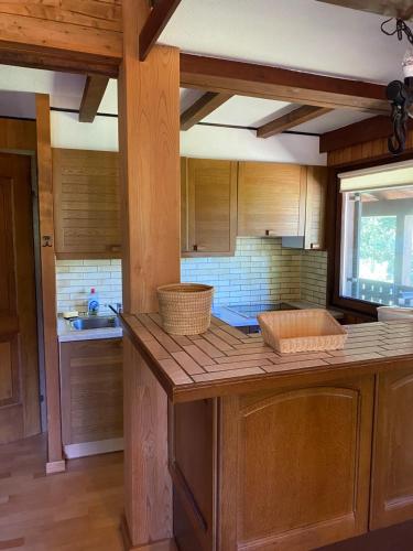 a kitchen with wooden cabinets and a counter top at Fichtenblockhütte in Sonnenalpe Nassfeld