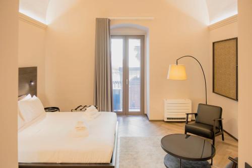 a hotel room with a bed and a chair at barneys design apartment in Taranto