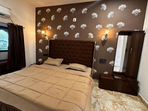a bedroom with a bed with white flowers on the wall at Rajmahel in Barvāla