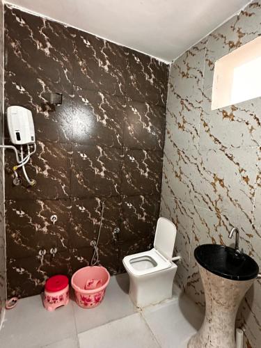 a dirty bathroom with a toilet and a sink at Rajmahel in Barvāla