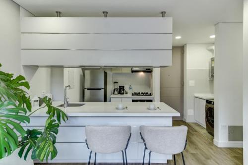a kitchen with white counters and two chairs at Hotel EspacioYa By Mario Rental 103 in Bogotá