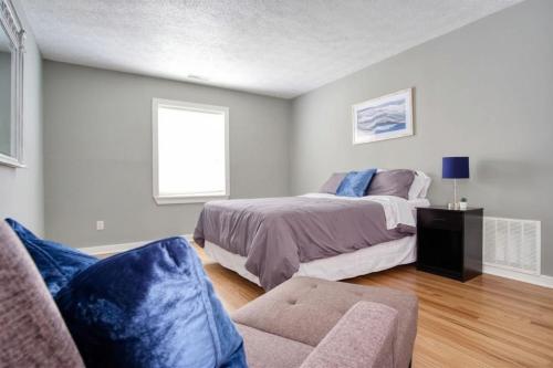 a bedroom with a bed and a couch and a window at Explore Indy in Perfect Location - Cozy 1BR in Indianapolis