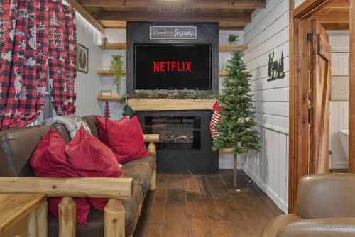 a living room with a couch and a tv and a christmas tree at Summer Breeze cabin at Cabin Fever in NC in Saluda