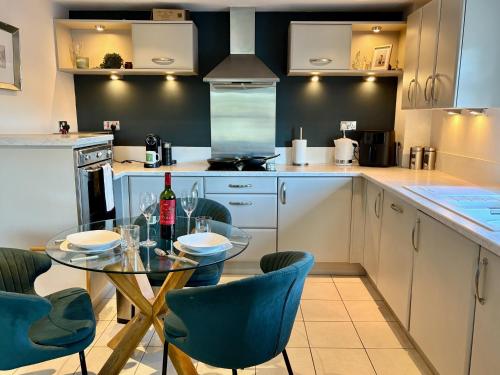 a kitchen with a glass table and blue chairs at FREE PARKING - Prime York City Centre Apartment near Minster with River View in York