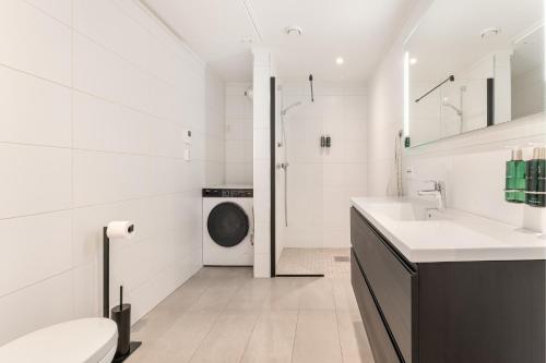 a bathroom with a washing machine and a sink at Aurora Apartments - Stryn View in Stryn