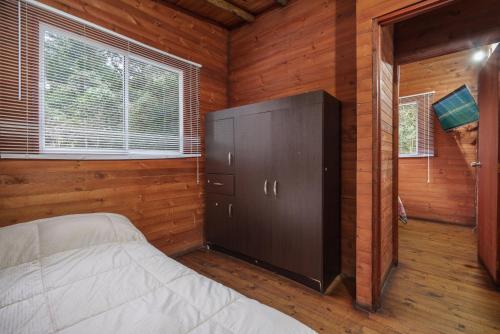 a bedroom with a bed in a wooden room at Cabañas La Silleta in Santa Elena