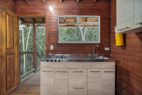 a kitchen with a sink and a window at Cabañas La Silleta in Santa Elena