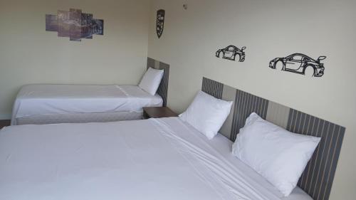 zwei Betten in einem Hotelzimmer mit weißen Kissen in der Unterkunft Ruan Beach in Guajiru