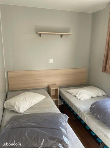a room with two beds in a room at Mobilhome Ligaropa climatisé 3 ch 6 pers camping des 7 fonts in Agde