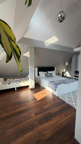 a bedroom with a large bed and wooden floors at Apartament Widok in Nowy Targ