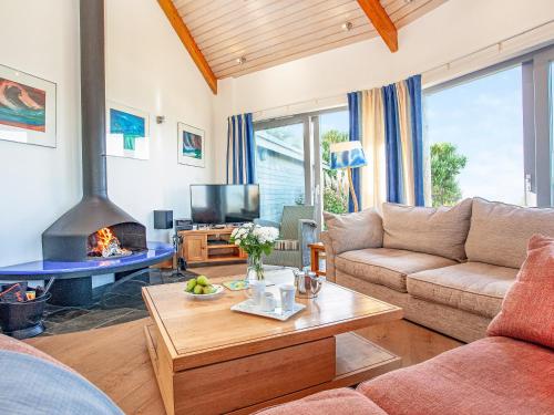 a living room with a couch and a fireplace at Shark Fin in Sennen