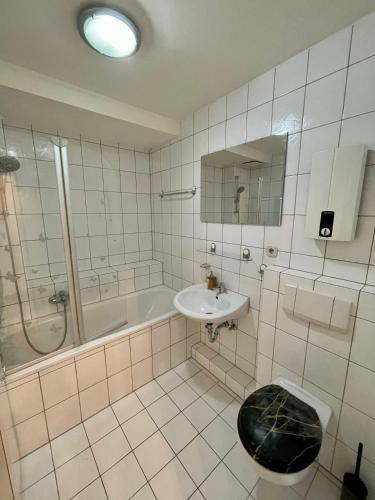 a bathroom with a sink and a tub and a toilet at Apartment mit Balkon - Nähe CHIO Aachen in Herzogenrath