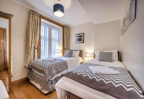 a bedroom with two beds and a window at Charming & Cosy Drymen Flat in Drymen