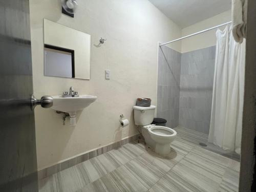a bathroom with a toilet and a sink at Suite El Ángel #7 in Tuxtla Gutiérrez