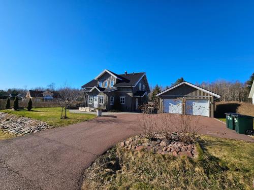 a black house with a driveway in front of it at Fahléns 10 Villa in Jomala