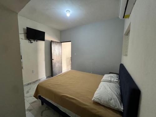 a bedroom with a bed and a tv on the wall at Suite El Ángel #7 in Tuxtla Gutiérrez
