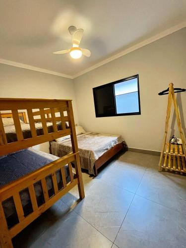a bedroom with two bunk beds and a flat screen tv at Casa Centro de Socorro prox a Feira de malhas in Socorro