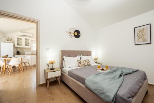 a bedroom with a large bed and a dining room at Destinys Village II in Zakynthos