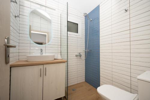 a bathroom with a sink and a toilet and a mirror at Destinys Village II in Zakynthos