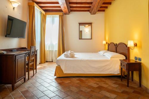 a hotel room with a bed and a television at La Corte dell'Anatra in Cortile