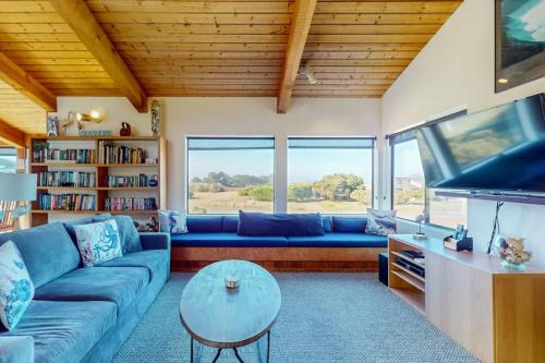 a living room with a blue couch and a tv at Prentiss Retreat in Sea Ranch