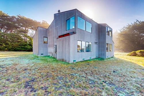 a house on top of a grass field at Prentiss Retreat in Sea Ranch