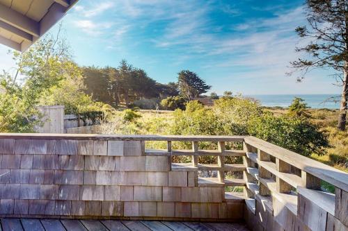 a wooden staircase leading to a deck with the ocean in the background at Meyer Getaway in Sea Ranch