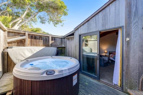 a hot tub sitting on a deck next to a building at Samson Getaway in Sea Ranch
