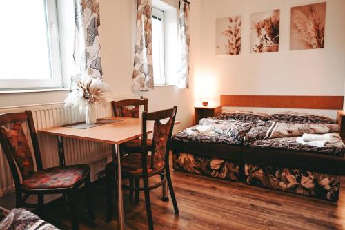 a bedroom with a bed and a table and chairs at Penzion U Kmotra in Borovany