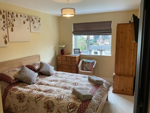 ein Schlafzimmer mit einem Bett, einer Kommode und einem Fenster in der Unterkunft Clauds Close in Hughenden