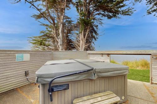 a container sitting on a sidewalk next to a fence at Stoney House in Sea Ranch