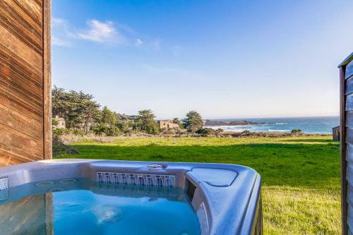 a hot tub in a backyard with a view of the ocean at Vista Grande in Sea Ranch
