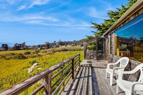 a deck with chairs and a view of the ocean at Thayer House in Sea Ranch