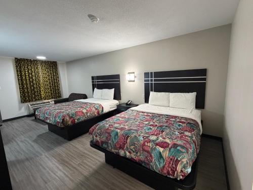a hotel room with two beds and a couch at Sunset Inn in Brady