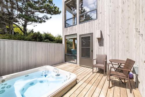 a hot tub on a deck with a table and chairs at Casa Contenta in Gualala