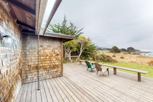 a porch with a bench and two chairs on it at Comstock Retreat in Sea Ranch