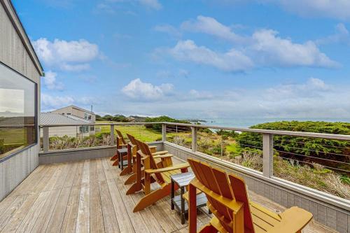a balcony with wooden chairs and a view of the ocean at Brammer's Bluff in Sea Ranch