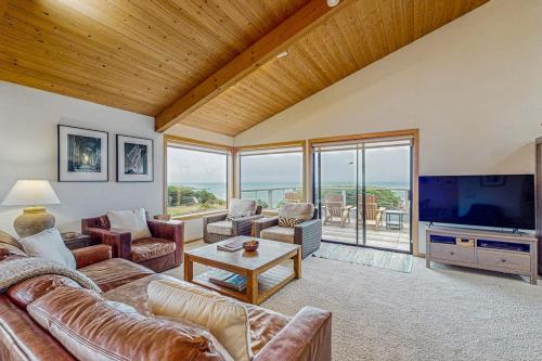 a living room with couches and a large television at Brammer's Bluff in Sea Ranch