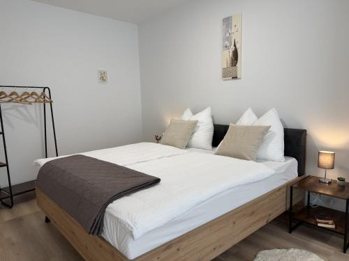 a bedroom with a large bed with white sheets and pillows at GMA Studio Apartment im Zentrum in Bad Ischl