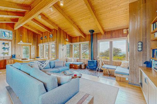 a large living room with a blue couch and tables at Gewing House in Sea Ranch
