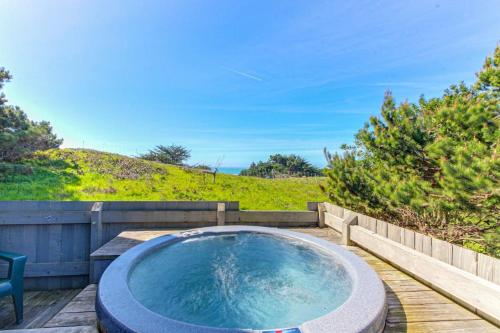 a hot tub sitting on a wooden deck at Gewing House in Sea Ranch