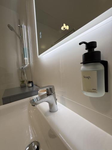 a soap dispenser on a sink in a bathroom at GMA Studio Apartment im Zentrum in Bad Ischl