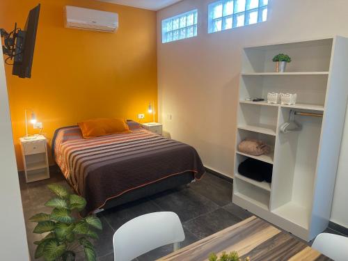 a bedroom with a bed and a yellow wall at Aqui es 6! in Banfield