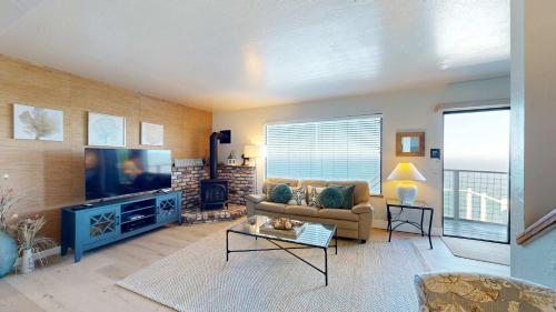 a living room with a couch and a flat screen tv at The Lookout Point in Gualala