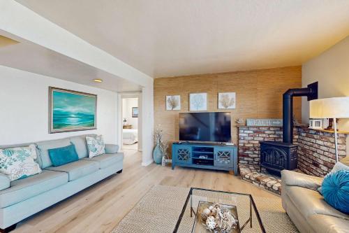 a living room with a couch and a fireplace at The Lookout Point in Gualala