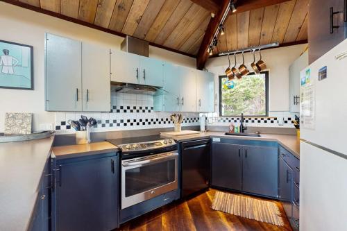 a kitchen with blue cabinets and a sink at Seas the Day in Sea Ranch