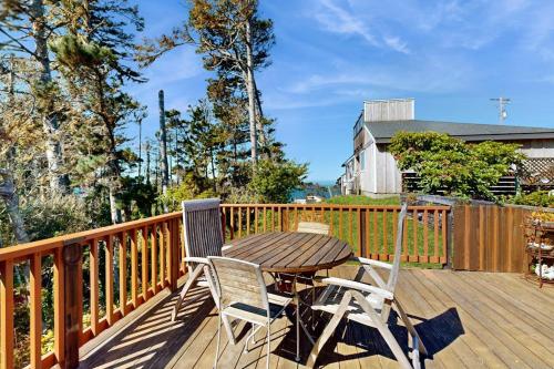 a wooden deck with a table and two chairs at Nature's Paradise in Gualala